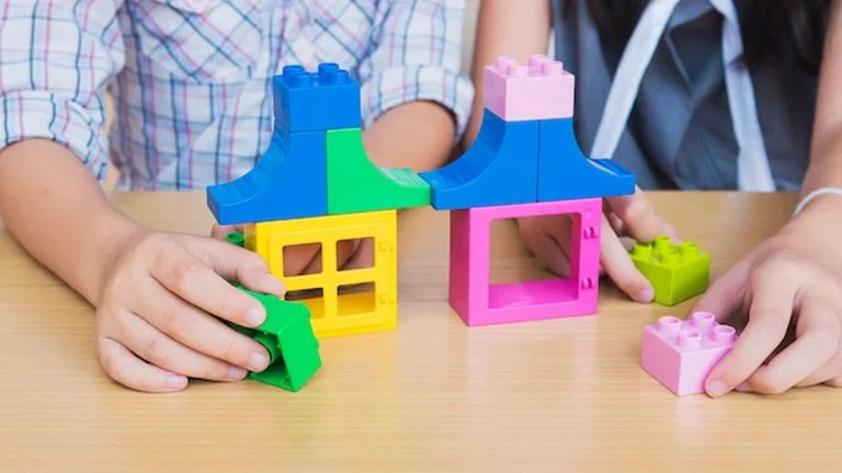 ילדים משחקים עם חלקי בנייה צבעוניים בהשראת תערוכת הלגו ברומא